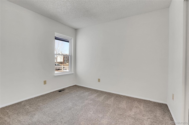 spare room featuring a textured ceiling and carpet