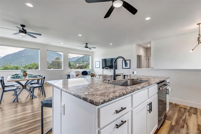 265 Upper Glenway, Palmer Lake, CO 80133 - kitchen with a ceiling fan, a kitchen island with sink, white cabinets, and recessed lighting