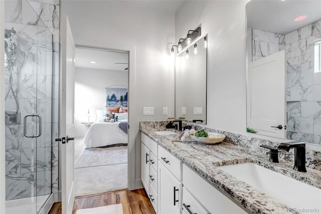 265 Upper Glenway, Palmer Lake, CO 80133 - bathroom with double vanity, a marble finish shower, wood finished floors, and connected bathroom