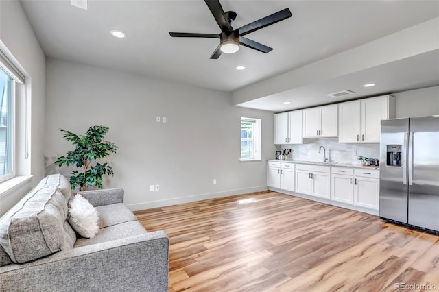 265 Upper Glenway, Palmer Lake, CO 80133 - kitchen with stainless steel refrigerator with ice dispenser, a ceiling fan, open floor plan, white cabinetry, and light wood-style floors