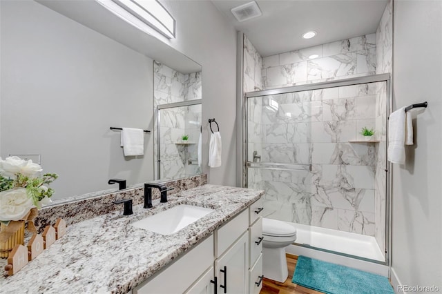 265 Upper Glenway, Palmer Lake, CO 80133 - bathroom featuring vanity, a marble finish shower, wood finished floors, and recessed lighting