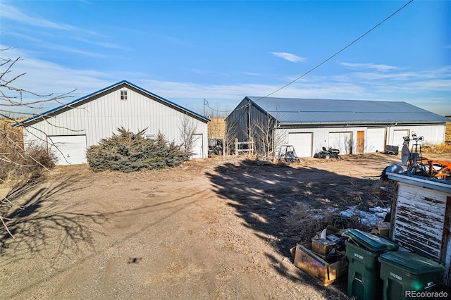 exterior space featuring a garage and an outbuilding