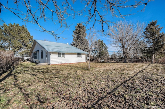 view of side of home with a yard