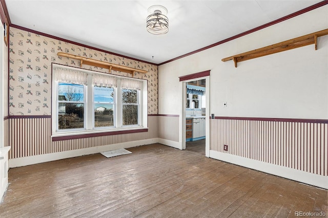 unfurnished room featuring crown molding, sink, and hardwood / wood-style flooring