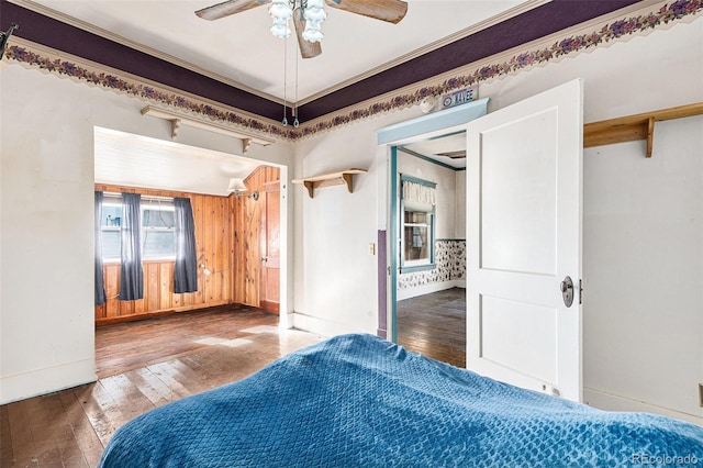 unfurnished bedroom with hardwood / wood-style floors, ceiling fan, and crown molding