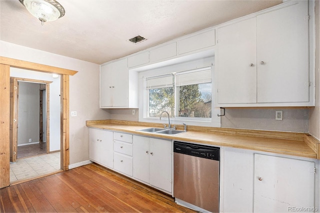 kitchen with sink, dishwasher, white cabinets, and light wood-type flooring