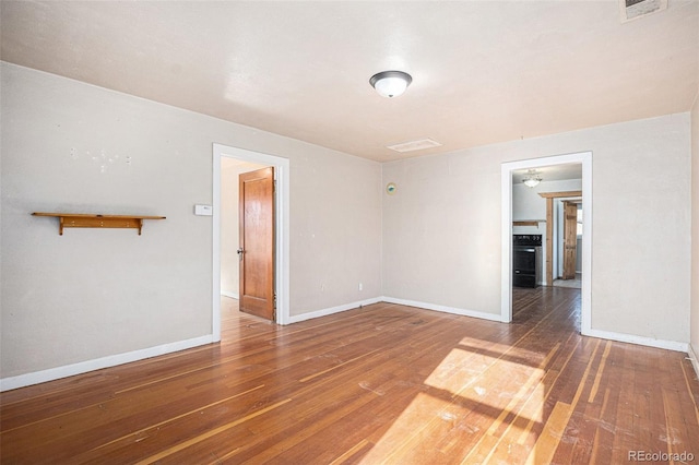 spare room with dark hardwood / wood-style floors