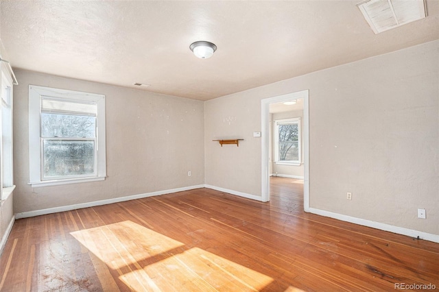 empty room with hardwood / wood-style floors and a textured ceiling