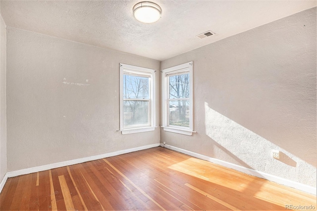 unfurnished room featuring hardwood / wood-style floors and a textured ceiling