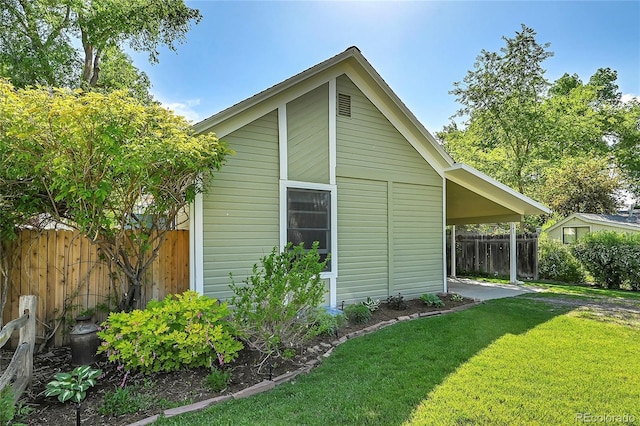 view of side of home featuring a lawn and fence