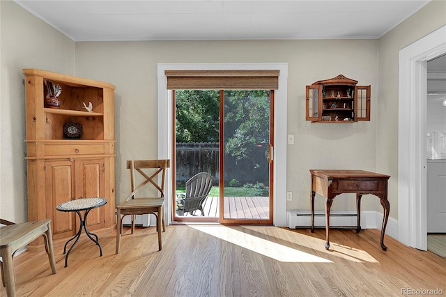 sitting room featuring a baseboard radiator and light wood finished floors