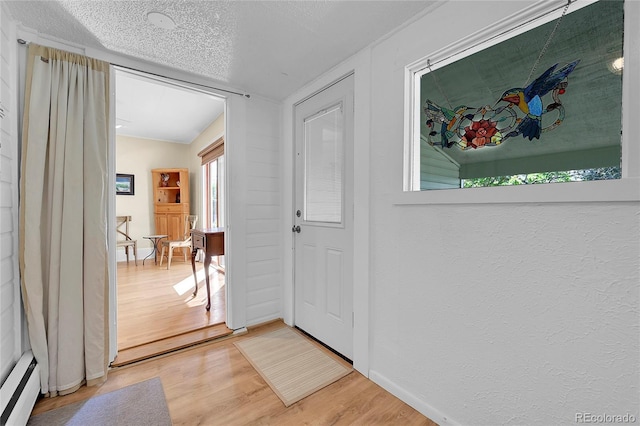 entryway with baseboards, a baseboard radiator, a textured ceiling, a textured wall, and light wood-type flooring