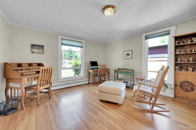 living area featuring a baseboard heating unit, crown molding, and light wood-style floors