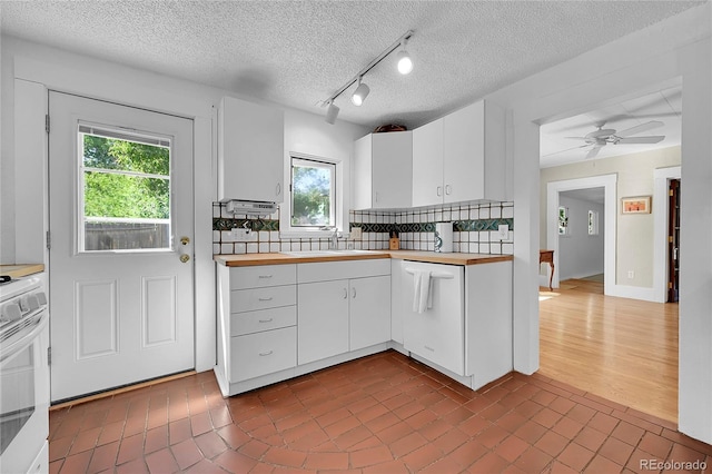 kitchen with white appliances, ceiling fan, decorative backsplash, white cabinetry, and butcher block counters