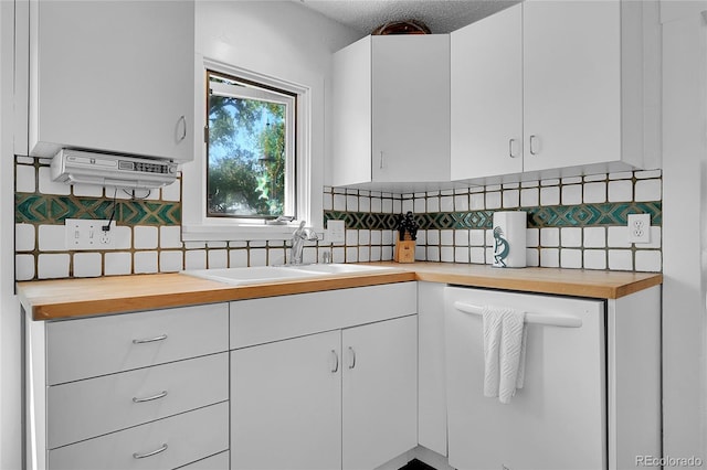 kitchen featuring a sink, wooden counters, white cabinets, and white dishwasher