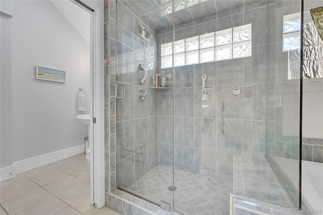 bathroom featuring tile patterned floors, baseboards, toilet, and a stall shower