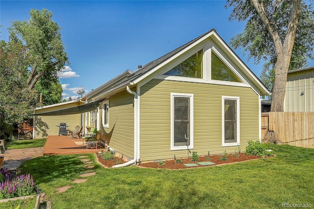 view of home's exterior featuring a yard, a deck, and fence