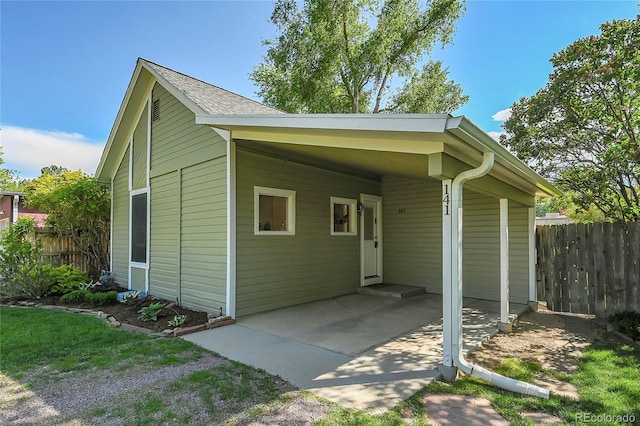 exterior space with an attached carport, driveway, and fence