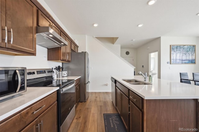 608 N Bersshine Ct, Aurora, CO 80137 - kitchen featuring stainless steel appliances, extractor fan, a center island with sink, wood finished floors, and light countertops