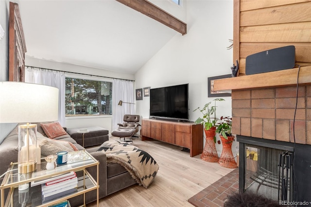 living room with high vaulted ceiling, a fireplace, wood finished floors, and beam ceiling