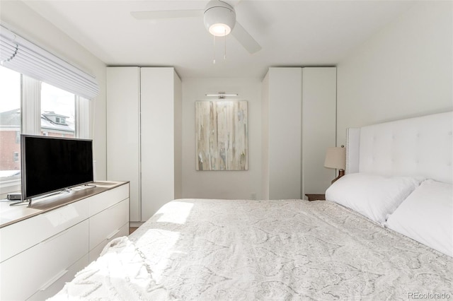 bedroom featuring ceiling fan and multiple closets