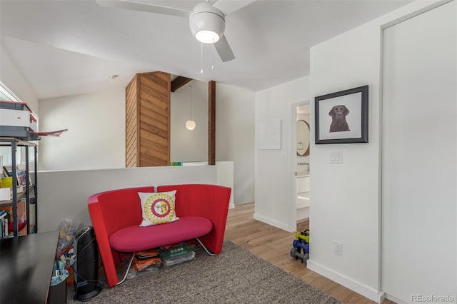 living area with light wood-style flooring, baseboards, and a ceiling fan