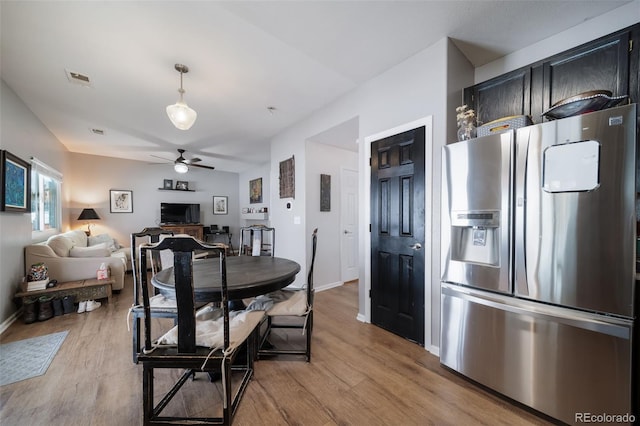 dining space with ceiling fan and light hardwood / wood-style flooring