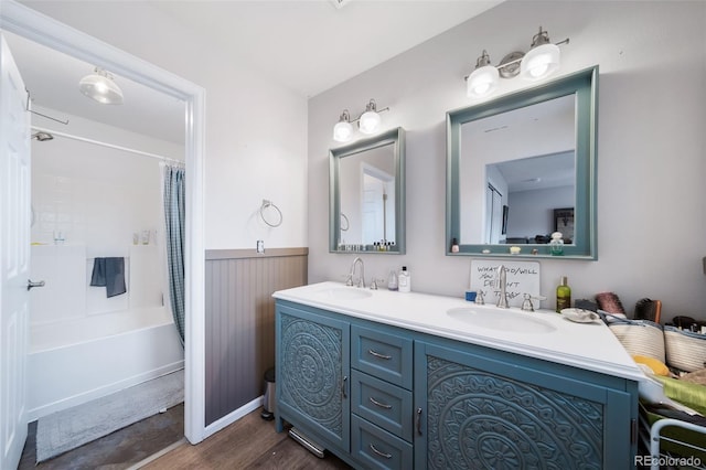 bathroom with hardwood / wood-style flooring, vanity, and shower / tub combo