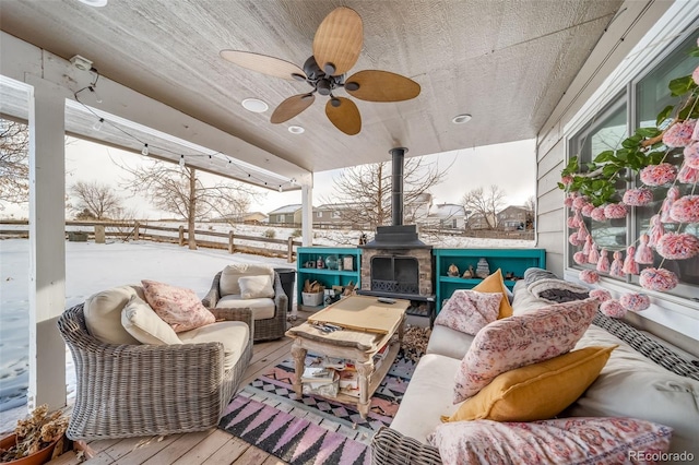 snow covered patio with an outdoor living space with a fireplace