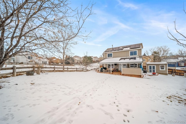 snow covered property with a porch and solar panels