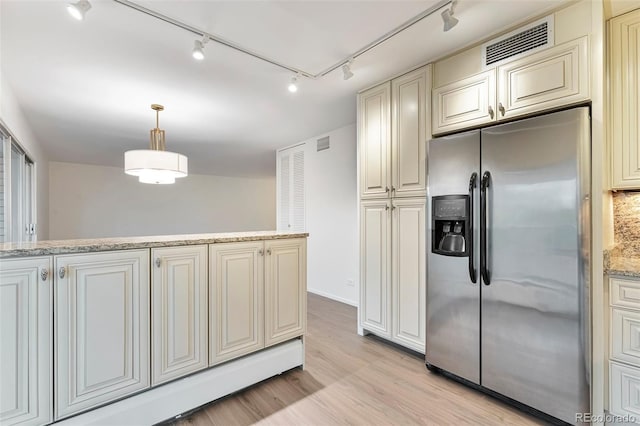 kitchen featuring visible vents, light wood-style floors, baseboard heating, stainless steel fridge with ice dispenser, and rail lighting