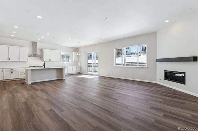 unfurnished living room with dark hardwood / wood-style flooring and sink