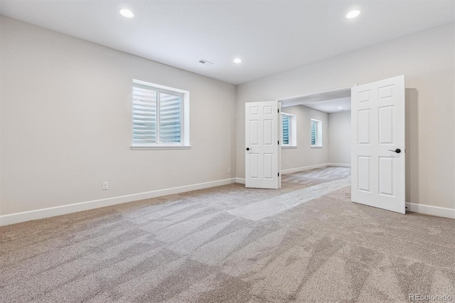 unfurnished room featuring light carpet