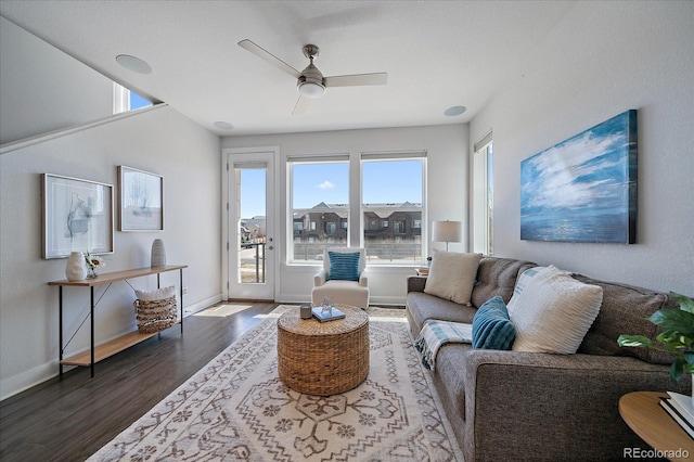 living area featuring a ceiling fan, wood finished floors, and baseboards