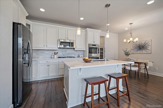 kitchen featuring a sink, stainless steel appliances, decorative backsplash, and white cabinetry