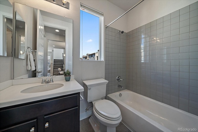 bathroom featuring a wealth of natural light, toilet, washtub / shower combination, and vanity