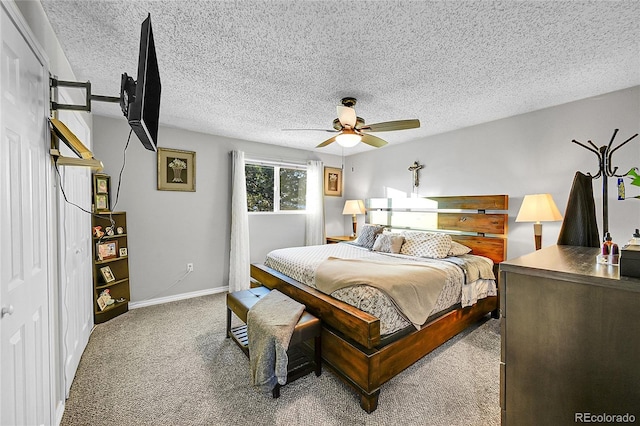 bedroom featuring carpet flooring, ceiling fan, and a textured ceiling