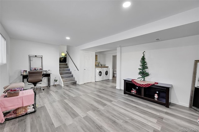 interior space with washing machine and dryer and light hardwood / wood-style flooring