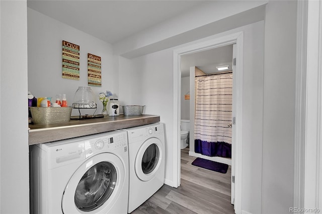 washroom with light wood-type flooring and washing machine and clothes dryer