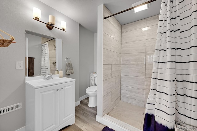 bathroom with a shower with curtain, hardwood / wood-style floors, vanity, and toilet