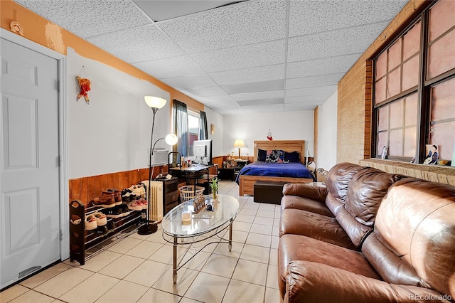 tiled living room with a paneled ceiling and wooden walls