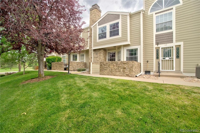 210 W Jamison Cir Unit 41, Littleton, CO 80120 - rear view of house with a chimney, a yard, and stone siding