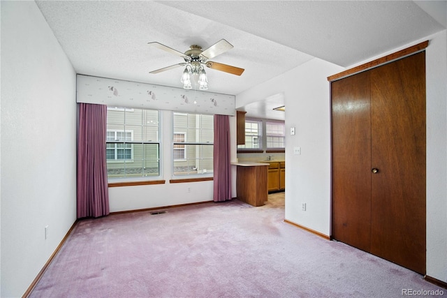 210 W Jamison Cir Unit 41, Littleton, CO 80120 - unfurnished bedroom with light colored carpet, a textured ceiling, ensuite bathroom, a closet, and a ceiling fan