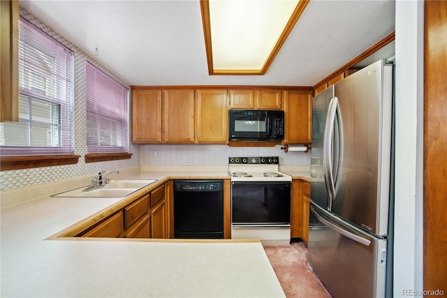 210 W Jamison Cir Unit 41, Littleton, CO 80120 - kitchen featuring black appliances, light countertops, decorative backsplash, brown cabinets, and a peninsula