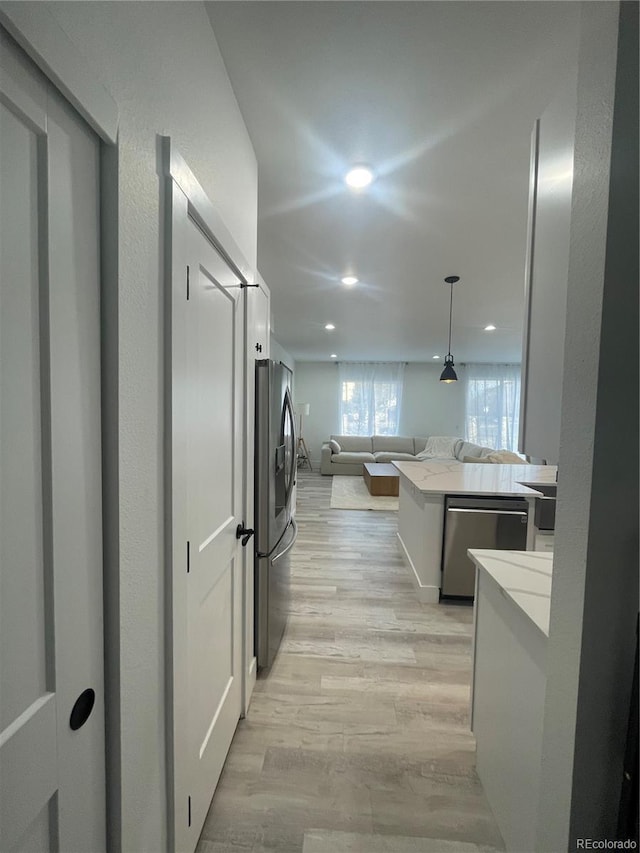 clothes washing area featuring light hardwood / wood-style floors