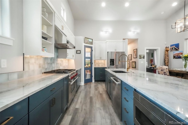 3630 Mesa Verde Rd, Monument, CO 80132 - kitchen with high end appliances, under cabinet range hood, white cabinets, light wood-style floors, and open shelves