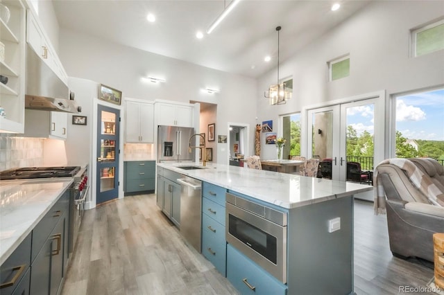 3630 Mesa Verde Rd, Monument, CO 80132 - kitchen with stainless steel appliances, decorative backsplash, a high ceiling, light wood-type flooring, and open floor plan