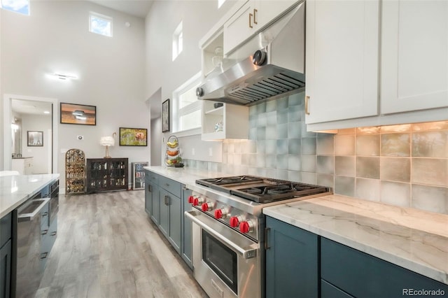3630 Mesa Verde Rd, Monument, CO 80132 - kitchen featuring stainless steel appliances, under cabinet range hood, open shelves, backsplash, and a high ceiling