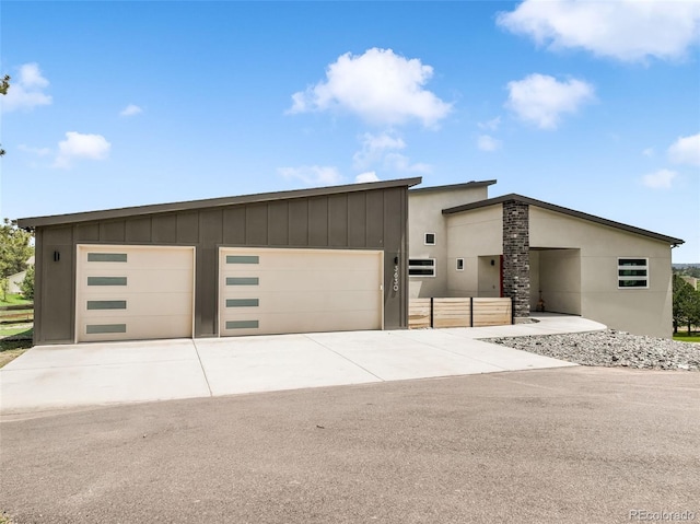 3630 Mesa Verde Rd, Monument, CO 80132 - contemporary house with driveway, an attached garage, and board and batten siding