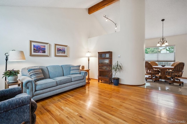 5513 S Yank Ct, Littleton, CO 80127 - living area with light wood-style floors, a chandelier, high vaulted ceiling, and beam ceiling